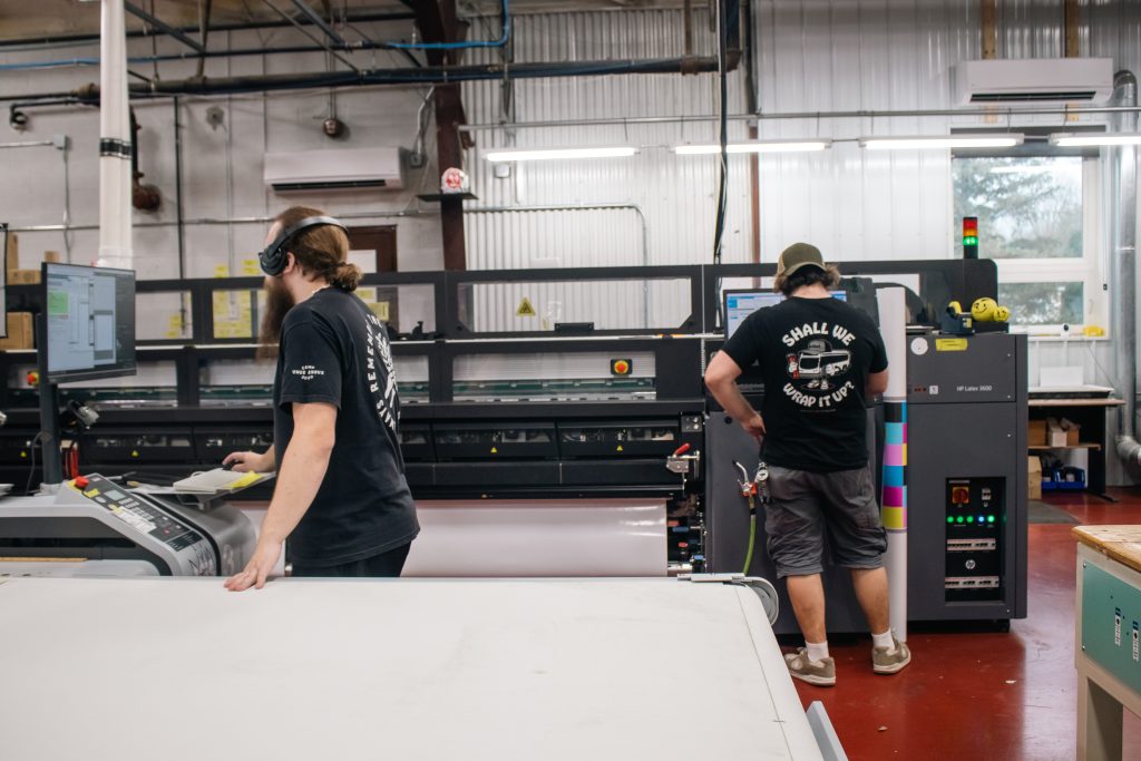 Seifert Transit Graphics team members printing vinyl graphics in preparation for install